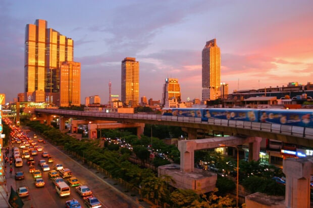 Sunset view of Bangkok cityscape with traffic and city towers in the evening