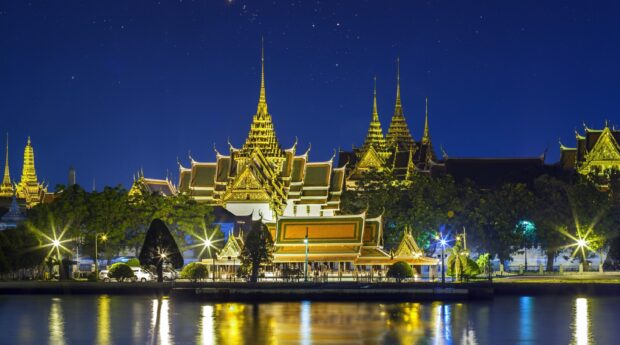 The Grand Palace in Bangkok illuminated at night under a starry sky