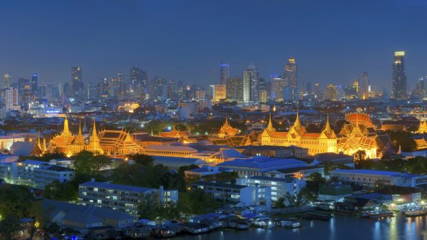 Night cityscape with Bangkok temples and skyline illuminated in evening light