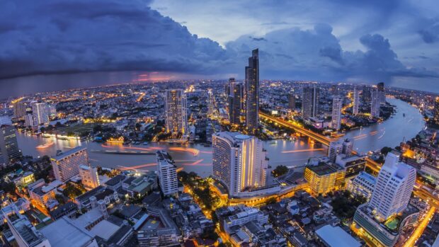 Stunning cityscape of Bangkok with river and skyscrapers at dusk showcasing vibrant city life