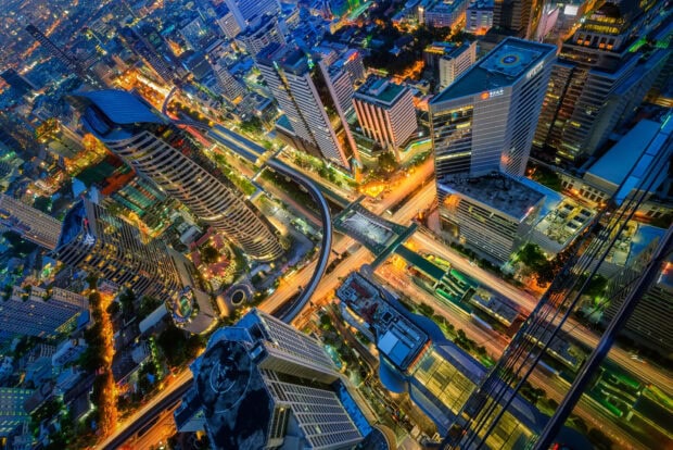 Aerial view of Bangkok cityscape with illuminated buildings and busy streets at night