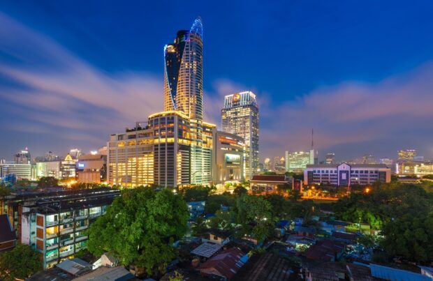 Modern architecture of Bangkok cityscape at dusk with bright lights and clear sky