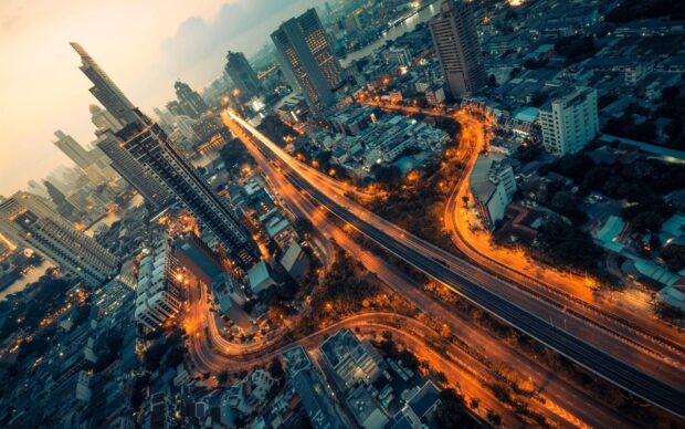 Aerial view of Bangkok cityscape with highway and skyscrapers at dusk