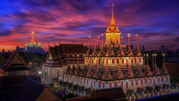 Golden temple with traditional Thai architecture in Bangkok at sunset sky