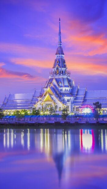 Beautiful temple architecture in Bangkok reflecting on calm water at sunset