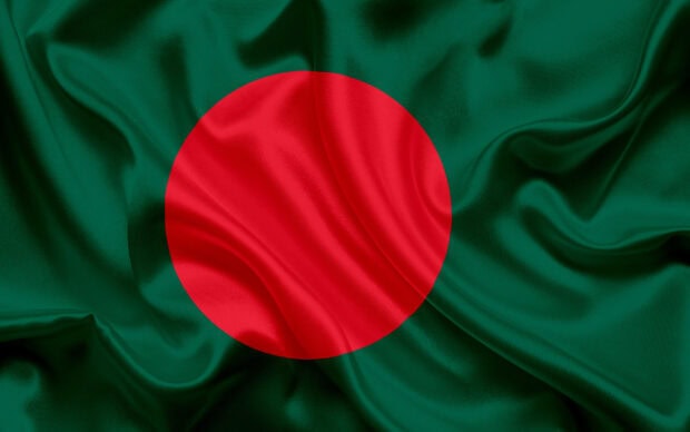 The flag of Bangladesh on a green silk fabric with a red circle in the center