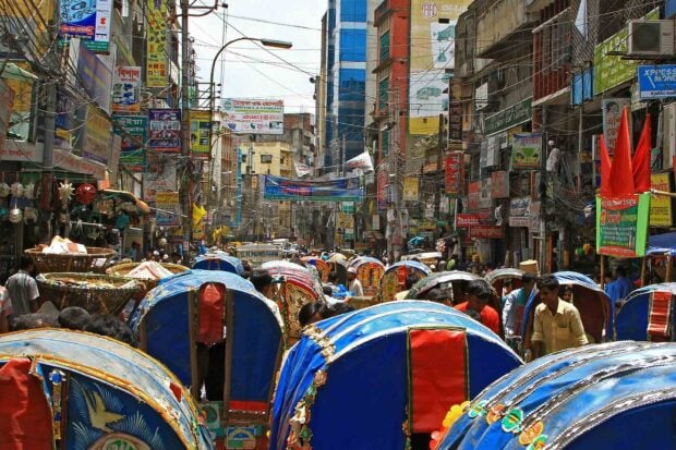 Crowded street with colorful rickshaws in Bangladesh cityscape