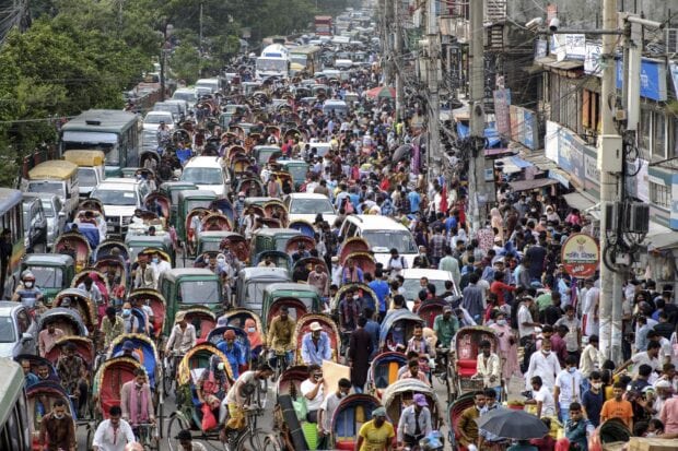 Crowded street with many rickshaws and people in Bangladesh traffic scene
