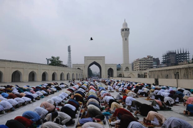 Large crowd praying at a mosque courtyard in Bangladesh during a religious event