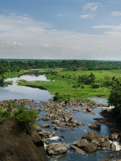 Lush green landscape with river and rocks in Bangladesh nature scene