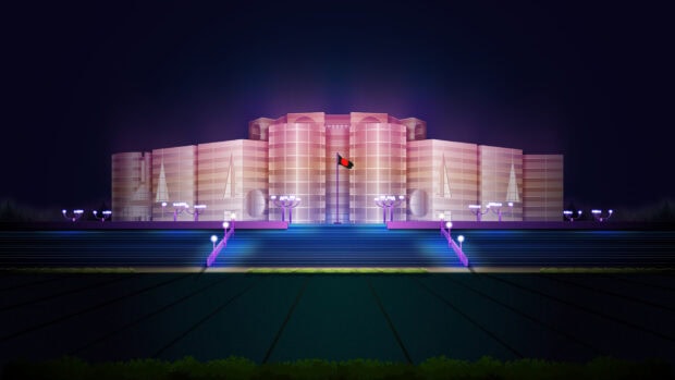 The national parliament house of Bangladesh illuminated at night with the flag in front