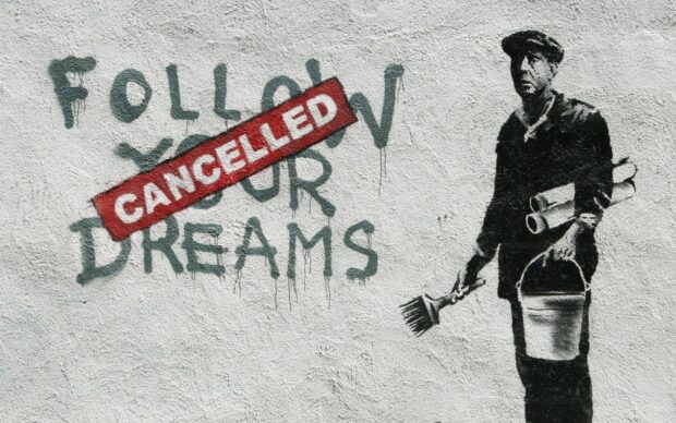Banksy artwork showing a man with paintbrush and bucket next to cancelled dreams graffiti