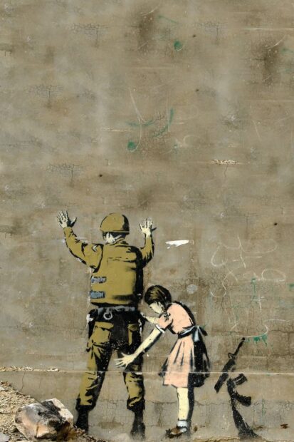 A girl frisking a soldier on a cracked wall graffiti showing Banksy stencil art