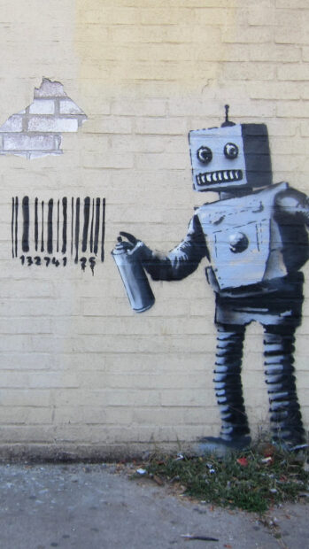 A robot holding a spray can painting a barcode on a brick wall in graffiti art