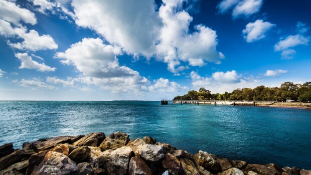 Rocky coastline and blue sea of Barbados under a bright sky with clouds