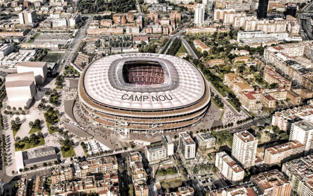 Aerial view of Camp Nou stadium and surrounding Barcelona cityscape with urban buildings and streets