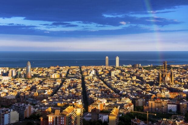 Barcelona cityscape with ocean view and towers under a vibrant sky