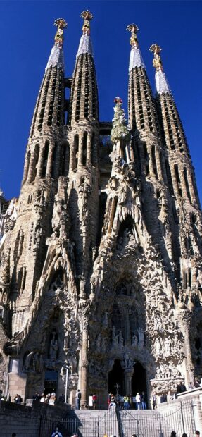 The famous Barcelona cathedral facade with detailed sculptures and towers under a clear blue sky