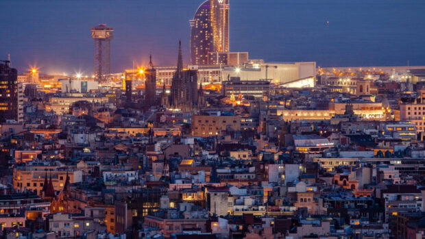 Night view of Barcelona city skyline with Barcelona city buildings and sea in the background