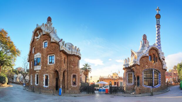Unique Antoni Gaudi architecture in Barcelona city with detailed stone and mosaic designs under clear blue sky