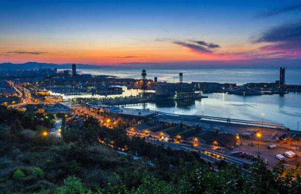 Barcelona city harbor and skyline at sunset with vivid colors and calm waters