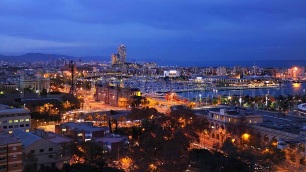 Barcelona city skyline at dusk with vivid lights and clear skies