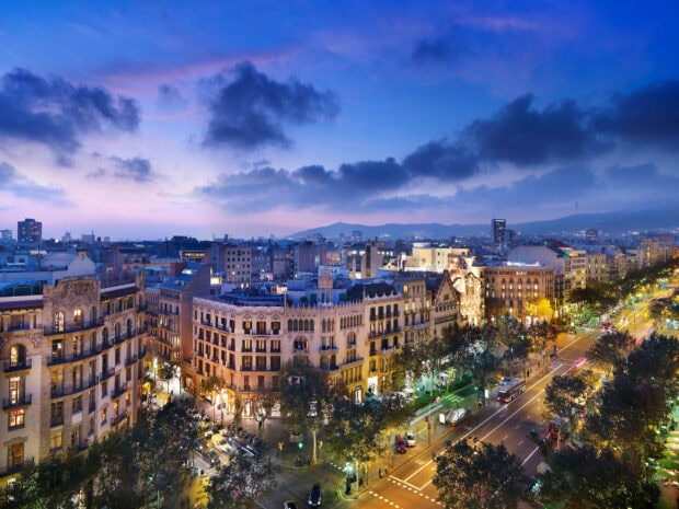 Cityscape of Barcelona at dusk with historic buildings and bustling streets in clear view