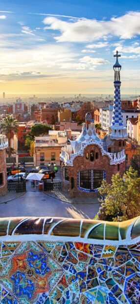Beautiful Gaudi mosaic artwork overlooking Barcelona cityscape at sunset