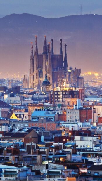 The Barcelona City skyline with the Sagrada Familia church at dusk in vibrant colors