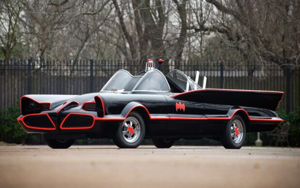 Classic Batmobile car with red accents parked outdoors in a high quality setting