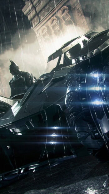 Dark rainy night scene with Batmobile and Batman standing in the background