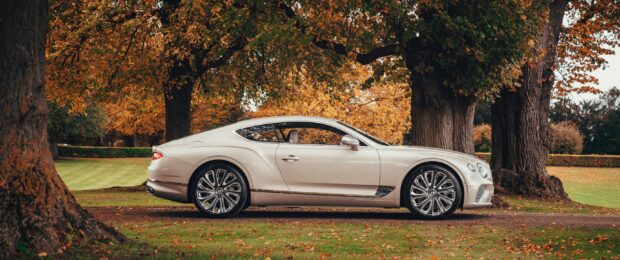 Elegant Bentley Continental car parked under autumn trees with orange leaves