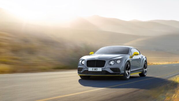 Bentley Continental car driving on an open road with mountains in the background