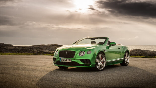 Green Bentley Continental convertible car parked on coastal road