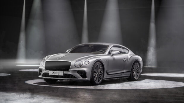 Silver Bentley Continental standing under spotlights in a dark studio environment