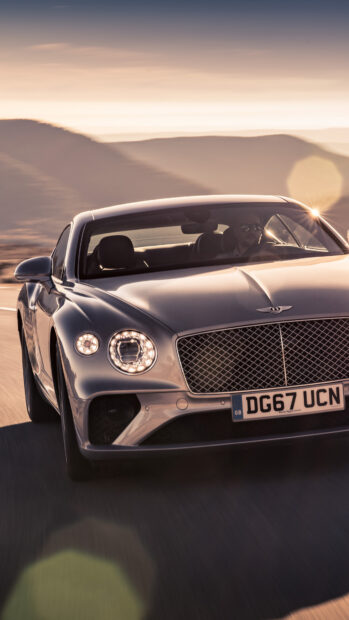 Bentley Continental car driving on road with mountain background