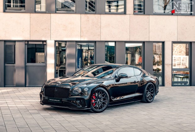 Black Bentley Continental car parked in front of a modern building facade