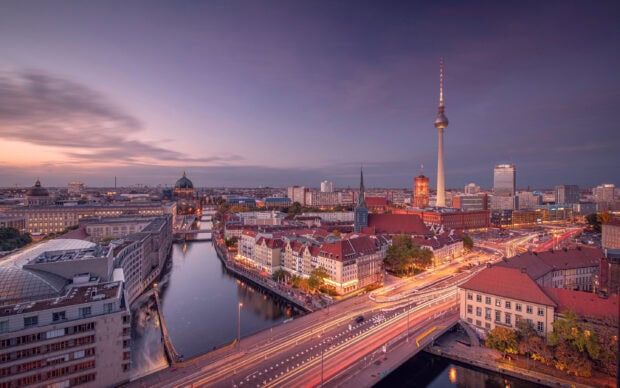 Berlin skyline with historic buildings and river at dusk showing vibrant city lights