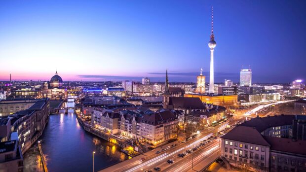 Berlin skyline at dusk with city buildings and river reflecting lights