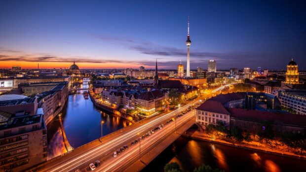 A stunning Berlin skyline at dusk featuring famous landmarks and clear river reflections