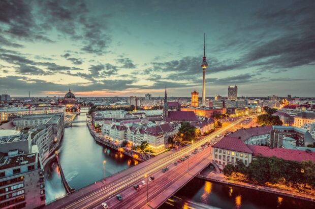 Berlin skyline view with historic buildings and river at sunset illuminated in warm light