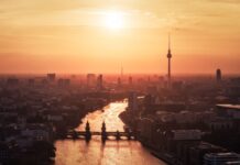 Berlin skyline with river and sunset highlighting the cityscape in warm tones