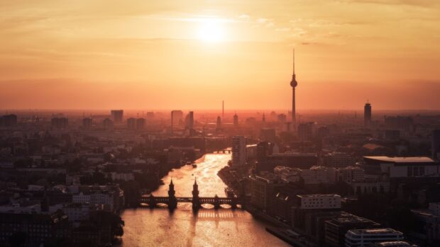 Berlin skyline with river and sunset highlighting the cityscape in warm tones
