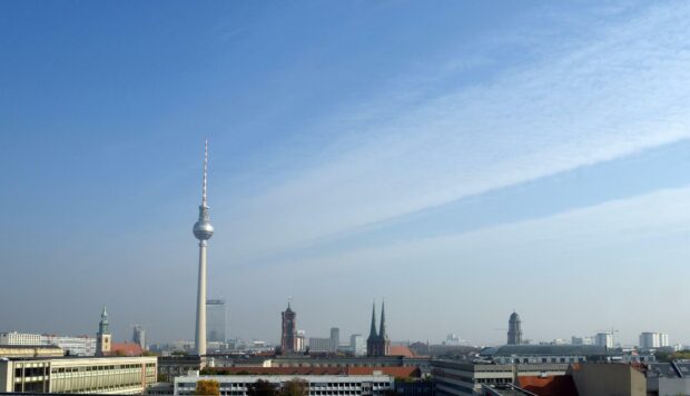 A clear view of Berlin skyline with iconic TV tower and city buildings under a blue sky