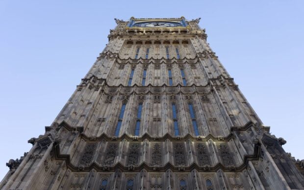 The detailed stone architecture of Big Ben tower under a clear blue sky