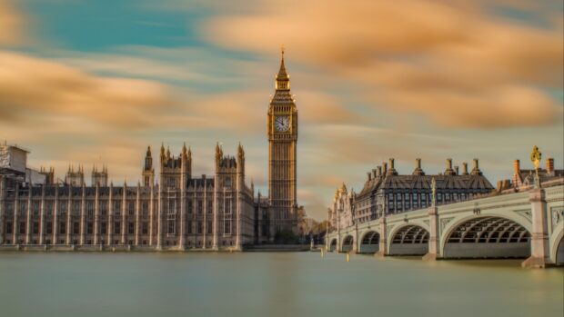 Big Ben clock tower with historic buildings and river in London at sunset