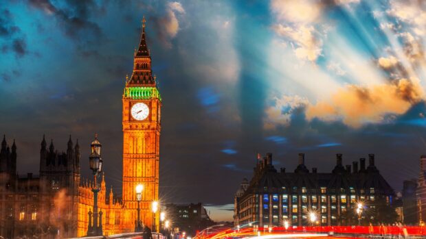 Big Ben tower illuminated at night with dramatic clouds in the sky