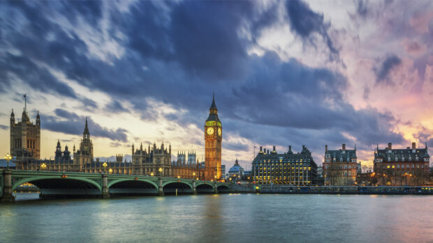 The historic Big Ben tower standing tall by the Thames River in London during sunset
