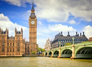 The iconic Big Ben clock tower and Westminster Bridge with the River Thames under a blue sky