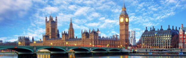 A stunning view of Big Ben tower and the Palace of Westminster under a bright blue sky